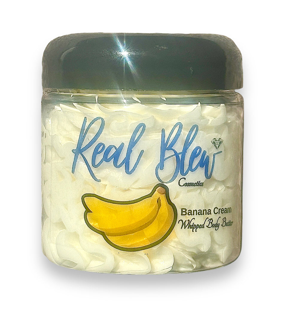 4oz Banana Creamy Whipped Body Butter Skincare Moisturizer with a black lid, yellow bananas on front and Real Blew Cosmetics in fancy writing; internal contents (body butter) is cream colored