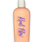 The image features a peach-colored body lotion in a clear plastic bottle with a white cap, labeled “Real Blew” in stylized cursive blue font. There’s also a small signature at the bottom right of the bottle underneath Real Blew labeled as "body lotion" The product is a peach scented body lotion🍑🧴