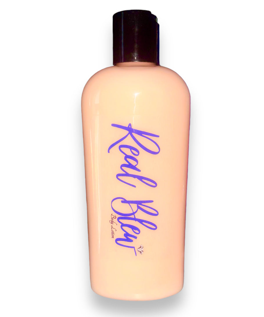 The image features a peach-colored body lotion in a clear plastic bottle with a black cap, labeled “Real Blew” in stylized cursive blue font. There’s also a small signature at the bottom right of the bottle underneath Real Blew labeled as "body lotion" The product is a peach scented body lotion🍑🧴